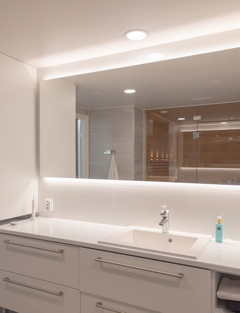 Sopra il lavabo, una luce a soffitto fa da punto di riferimento e una retroilluminazione a specchio aggiunge luce indiretta allo spazio. ©LedStore