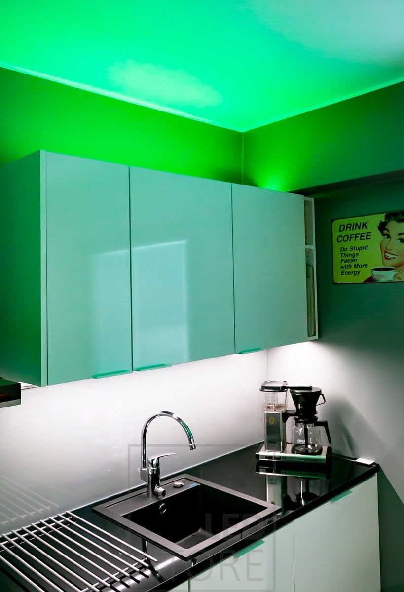 Illuminazione d'atmosfera versatile RGB+W con striscia led, creata per la cucina, striscia led in una superficie a basso profilo sopra i mobili. La luce è disponibile anche in bianco 4000K se si desidera un'illuminazione d'atmosfera più neutra. Il piano di lavoro è illuminato da una striscia led monocromatica. Ledstore.fi