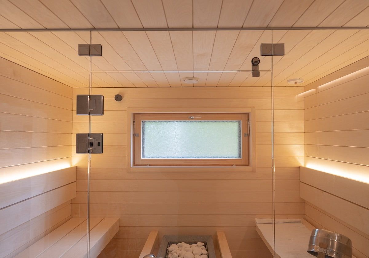 Sauna con strisce led sullo schienale che illuminano verso l'alto. Due strisce LED sono sufficienti per l'illuminazione della sauna quando la luce si lascia aprire.