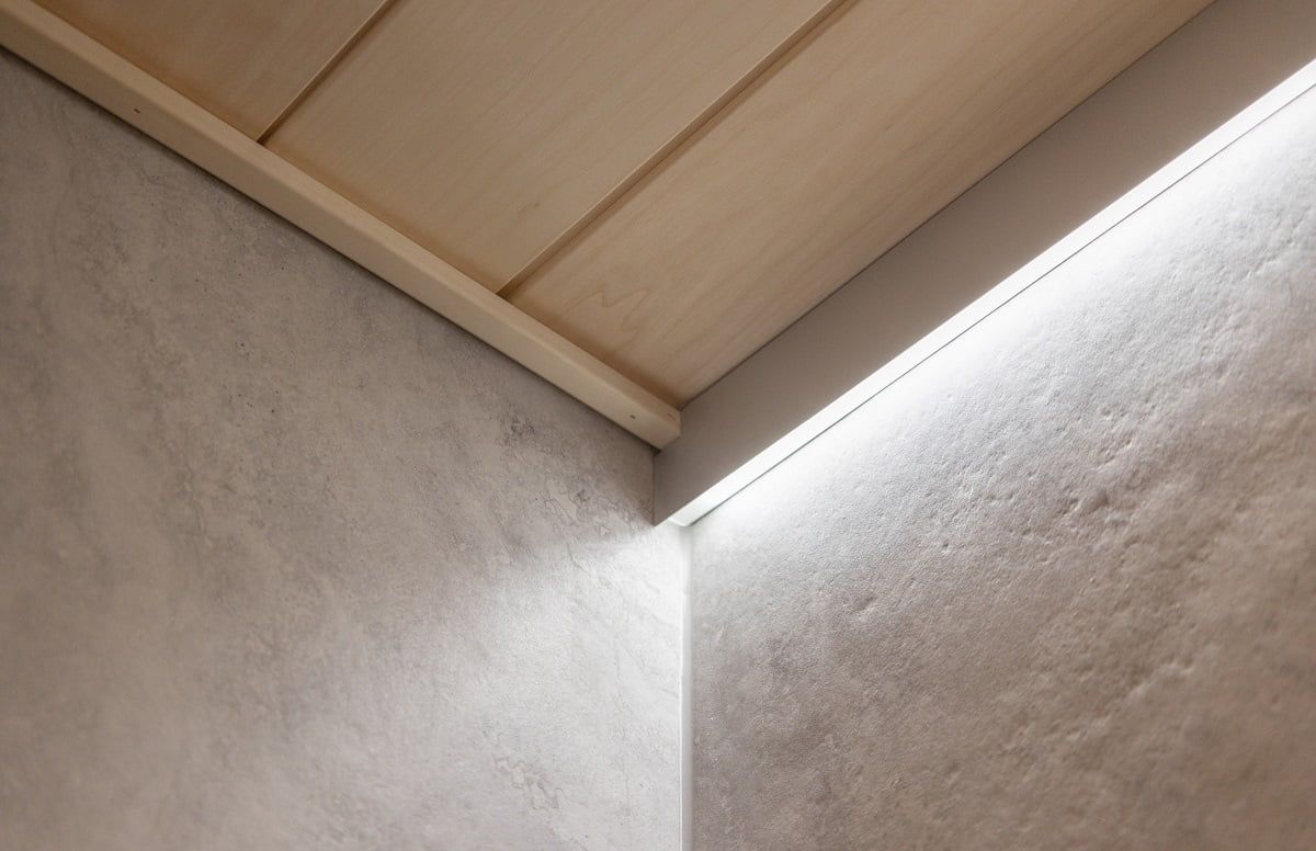 Nel bagno, l'illuminazione indiretta è stata creata con un profilo di alluminio che sostituisce i pannelli del soffitto. ©LedStore
