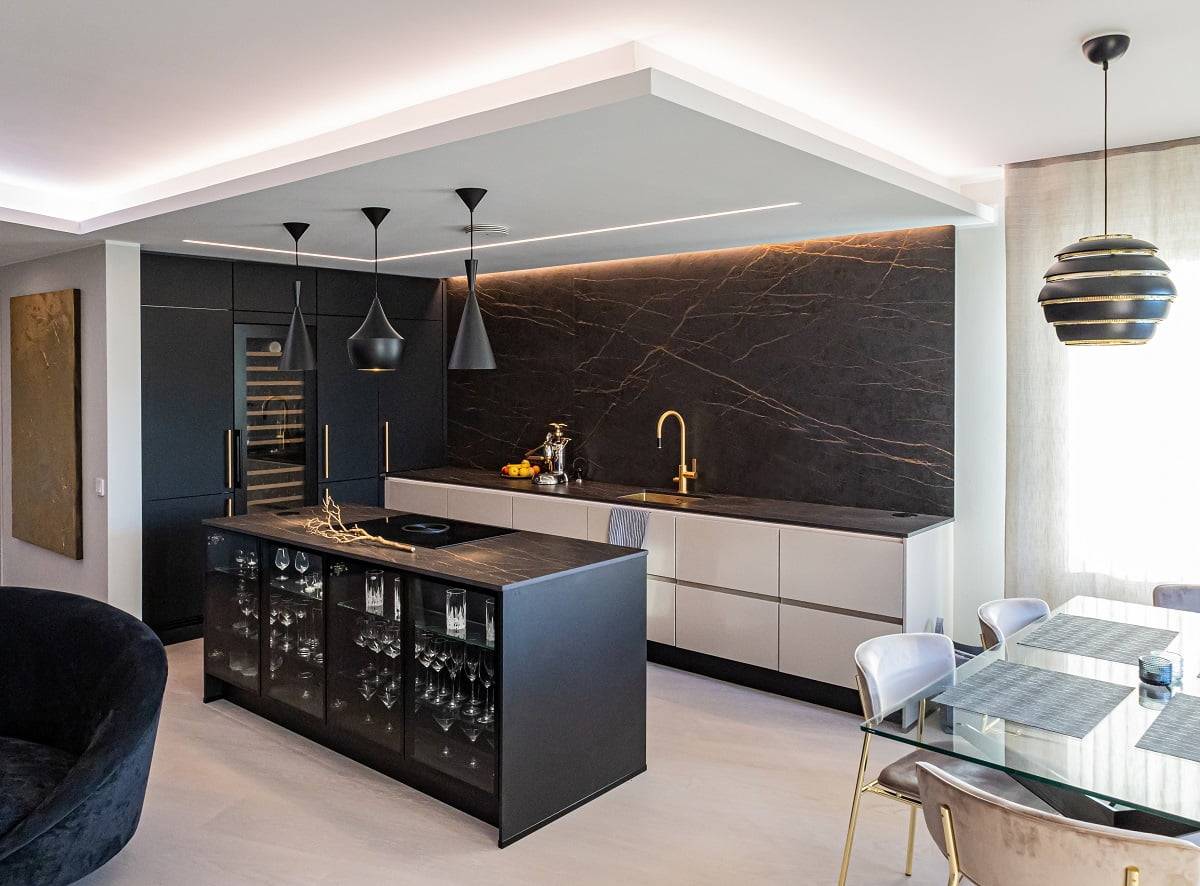 L'illuminazione a strisce led avvolge i bordi del soffitto ribassato della cucina.