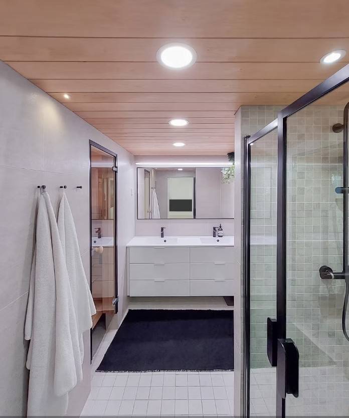 Illuminazione del bagno con luci a pannello, luci spot, luci a binario LED davanti allo specchio e punti impermeabili sul soffitto.