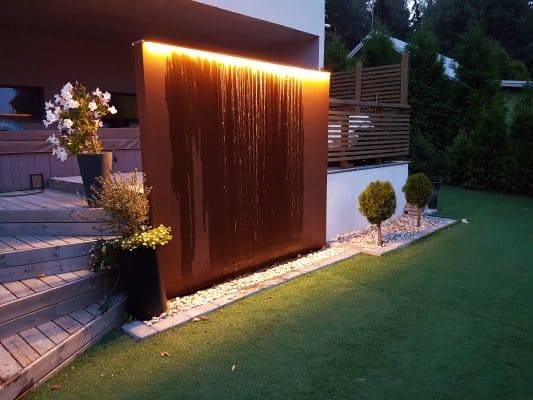 Un moderno gioco d'acqua per il giardino, con una striscia LED in cima che si illumina verso il basso.