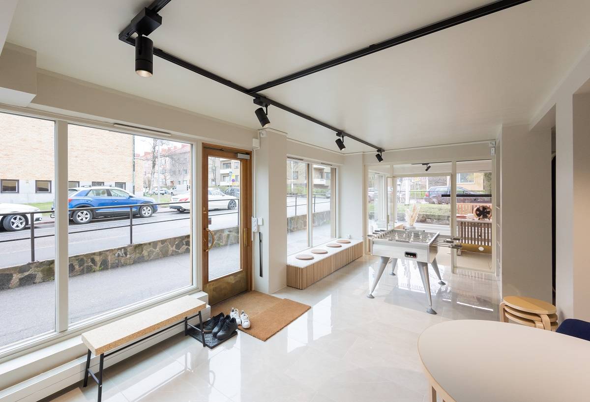 Ufficio con superfici luminose, binario trifase nero sul soffitto con quattro faretti neri.