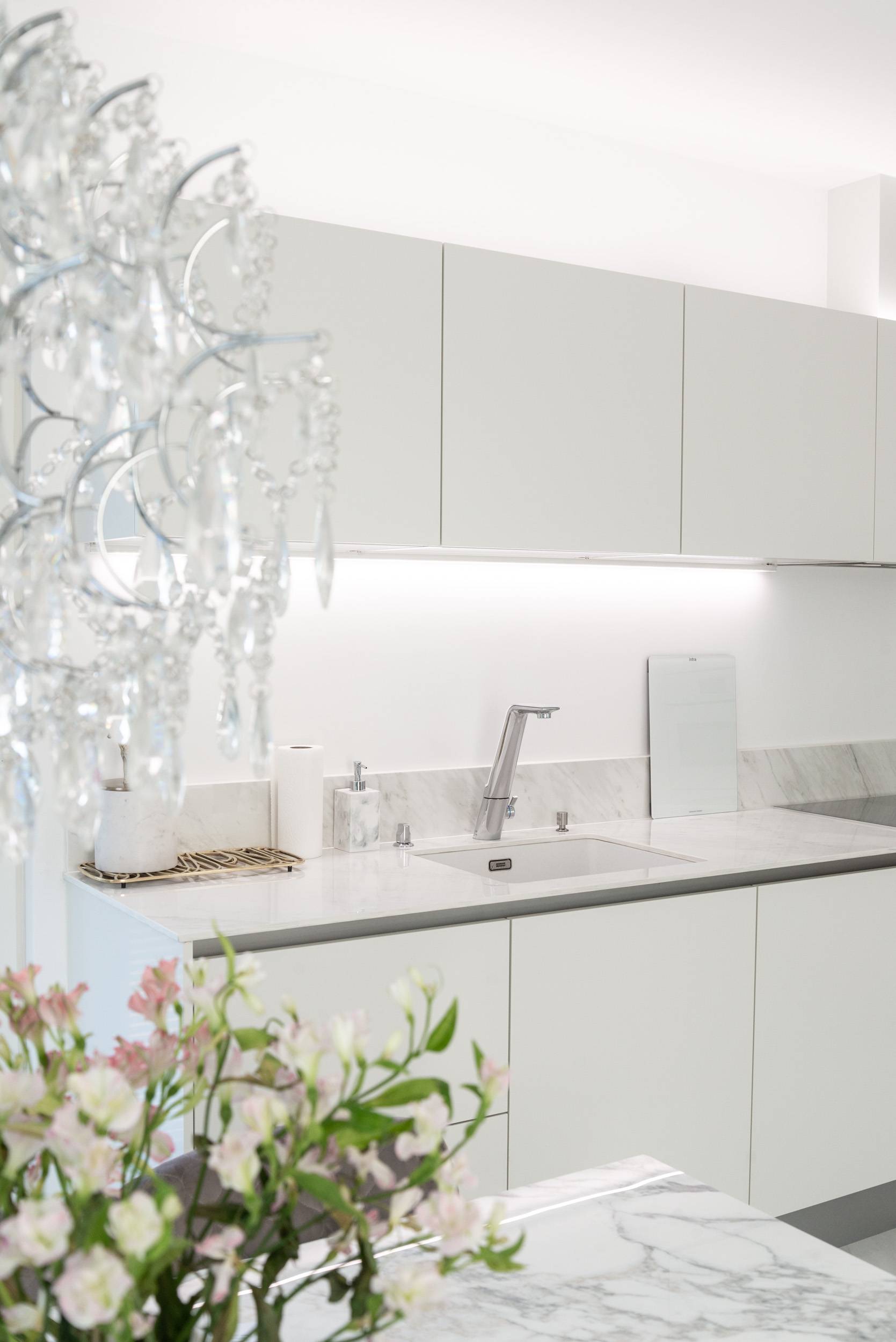 Strisce LED sopra e sotto il livello dell'armadio della cucina.