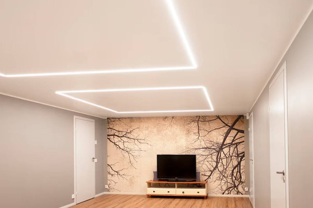 Un soggiorno minimalista in una casa di famiglia a Kaitamäki, Espoo, dove le plafoniere LED di LedStore.fi creano uno schema di illuminazione elegante. Il soggiorno è caratterizzato da un tavolo per la TV e da un suggestivo murale, accentuato da un'illuminazione LED di alta qualità.