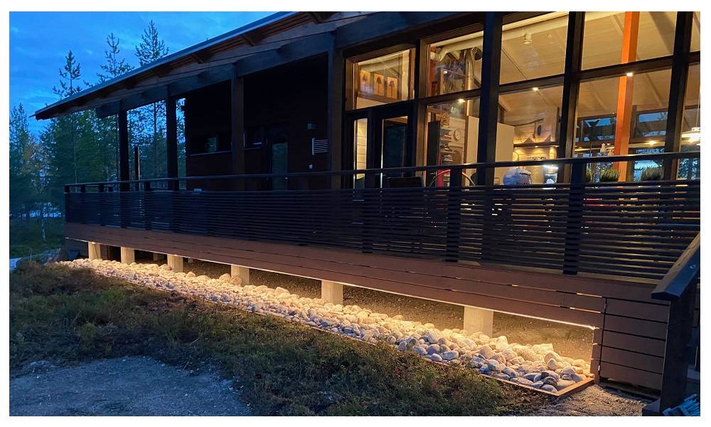 Nastro LED illuminato sul basamento della terrazza al tramonto.