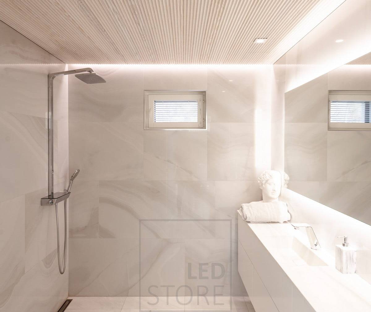 Il bagno è dotato di un'illuminazione versatile e d'atmosfera. HALO 1200 come specchio luminoso e spot a led CHEAP KANTTI sul livello che illumina il viso dall'alto. Striscia led installata nella scanalatura tra soffitto e parete per illuminare lo spazio con una luce d'atmosfera indiretta attraverso la parete. Ledstore.fi  