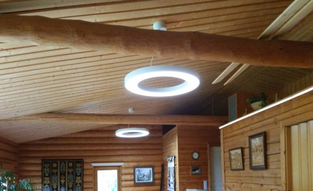 Gli interni in legno con luci circolari a LED illuminano la calda luce; le pareti e il soffitto in legno creano un fascino rustico con opere d'arte incorniciate, un orologio e arazzi.