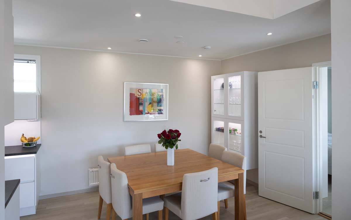 Lampade a led nella zona pranzo con spot a incasso nel soffitto e nella vetrinetta anch'essa illuminata con strisce a led.