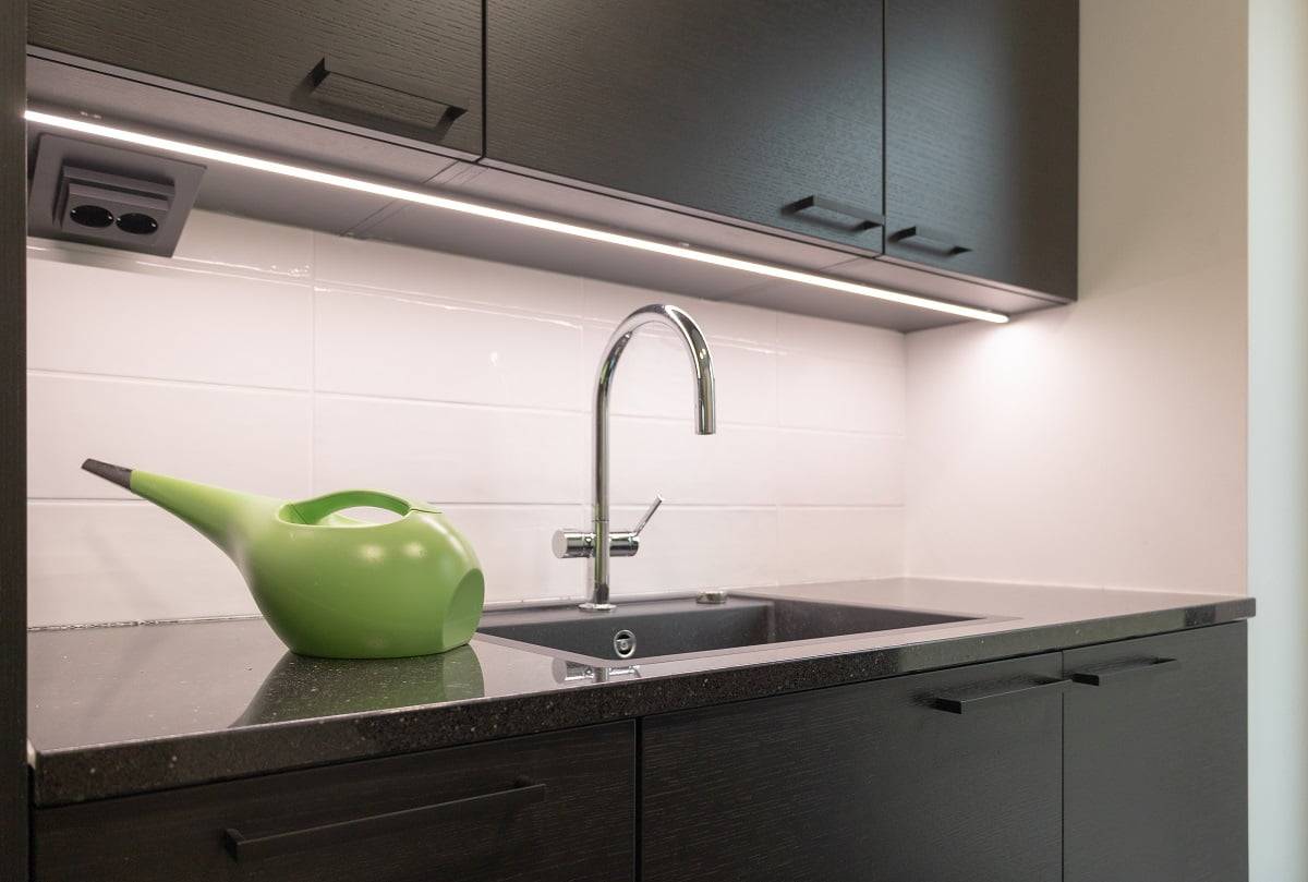 Sul piano di lavoro del ripostiglio, la superficie scura è illuminata da una striscia LED in un profilo di alluminio nero. ©LedStore