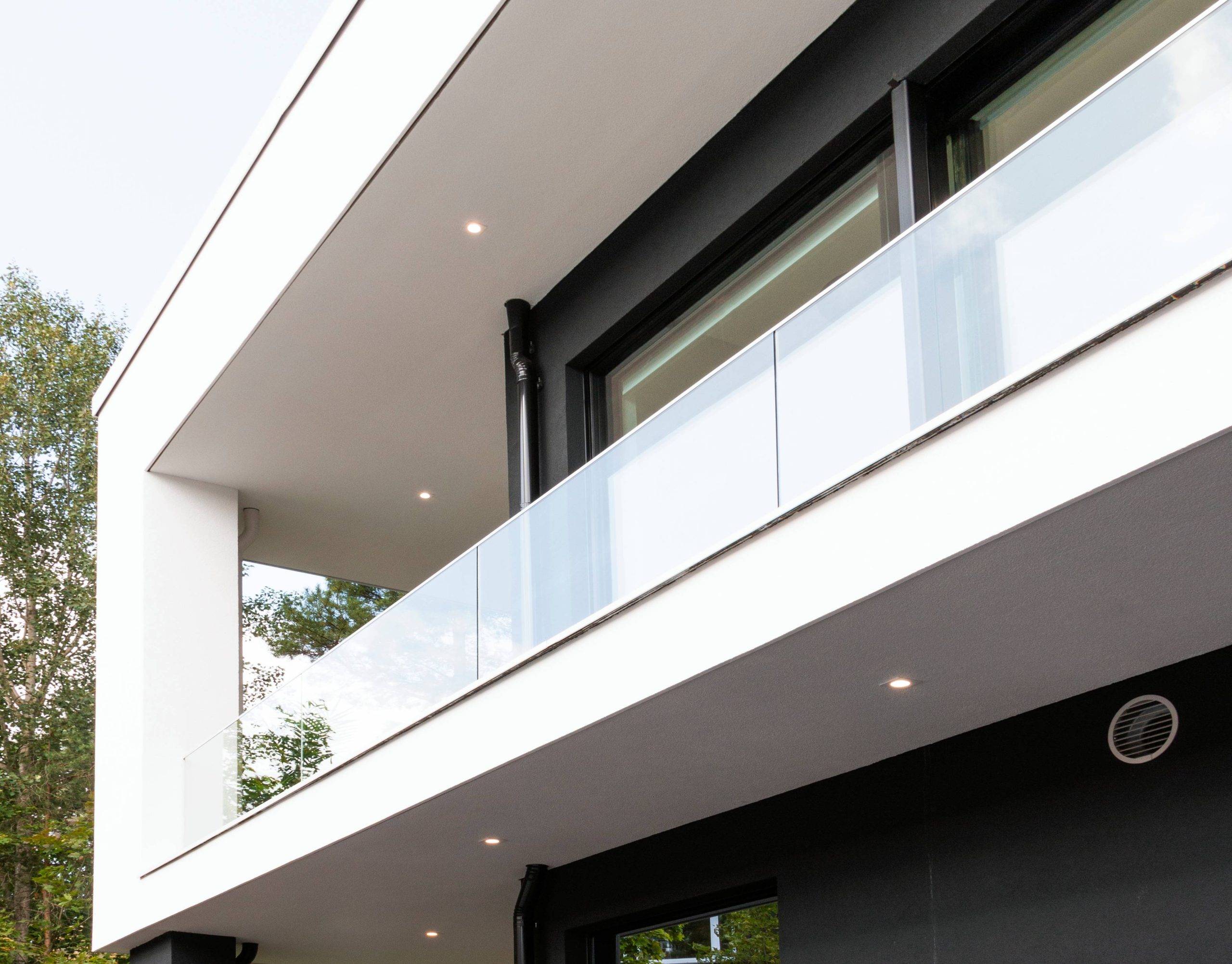 Nel negozio online di LedStore.fi troverai deliziose soluzioni di illuminazione a LED che conferiscono un aspetto moderno all'esterno di un edificio a due piani. Il design minimalista è messo in risalto dagli effetti LED sulle grandi finestre e sul balcone in vetro. L'elegante mix di superfici bianche e grigio scuro della struttura crea un bellissimo contrasto di temperatura con il verde sotto un cielo limpido.