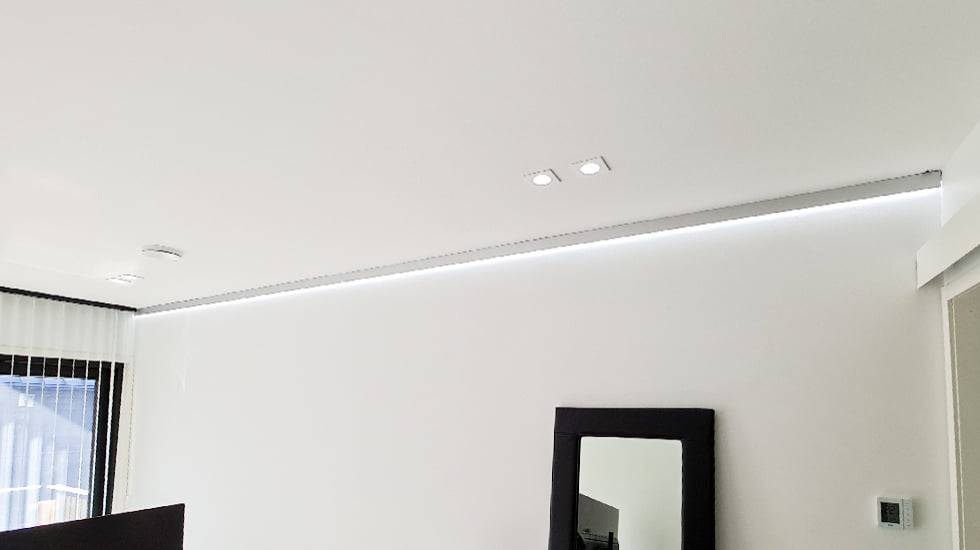 Luce indiretta al confine tra soffitto e parete con luce bianca fredda.