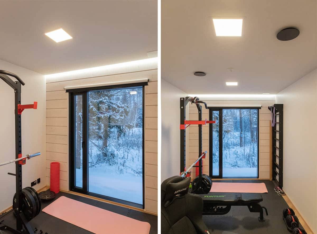 Una piccola palestra con un'ampia finestra verso l'esterno, due piccoli pannelli luminosi nel soffitto e una striscia a led sopra la finestra.