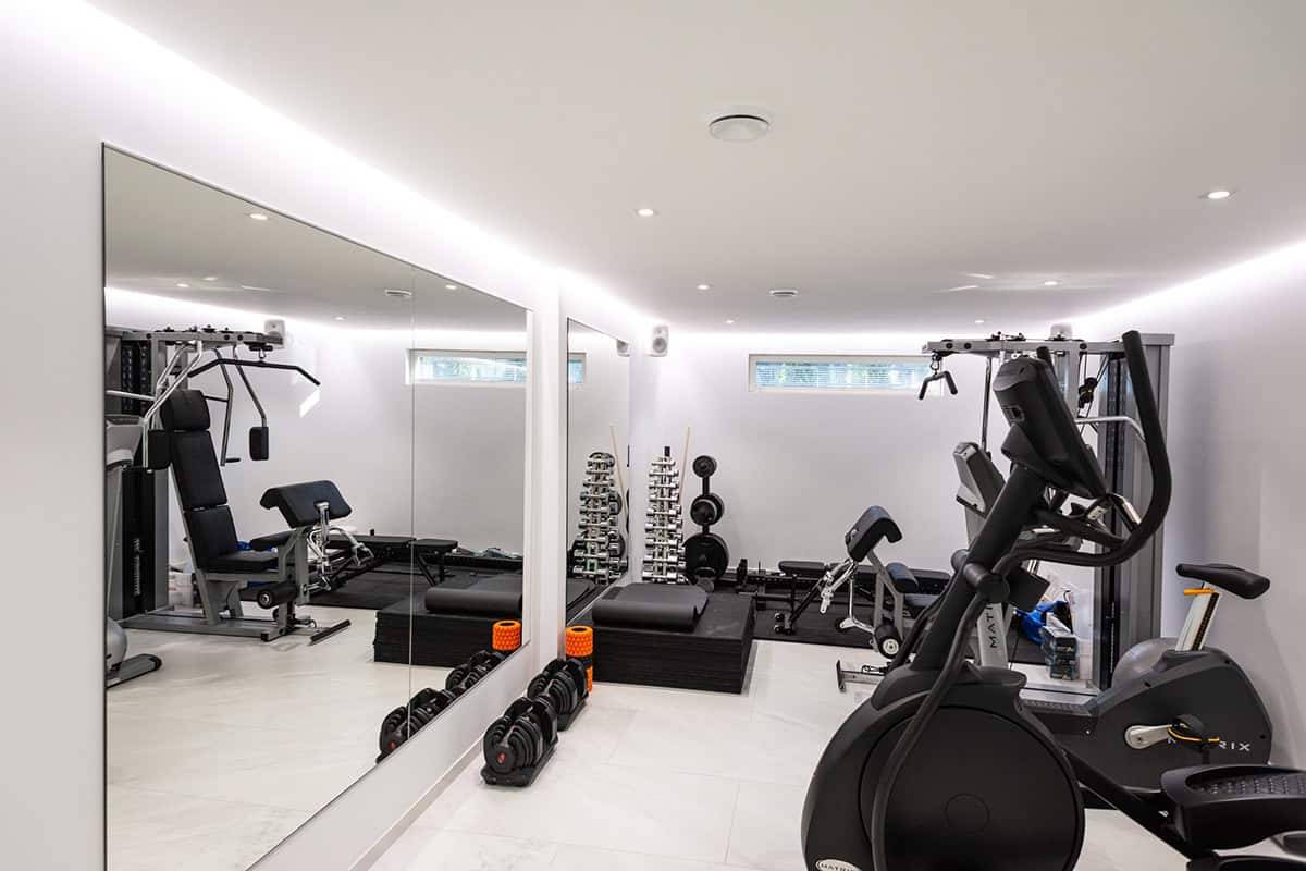 Una piccola palestra con illuminazione a strisce LED e faretti.