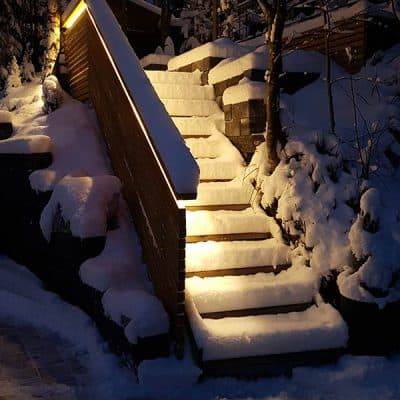 Le scale esterne coperte di neve riflettono la luce della balaustra.