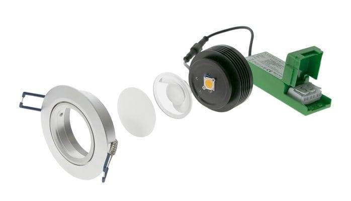 Vista esplosa del downlight LED: corpo, lente, modulo LED e trasformatore verde.