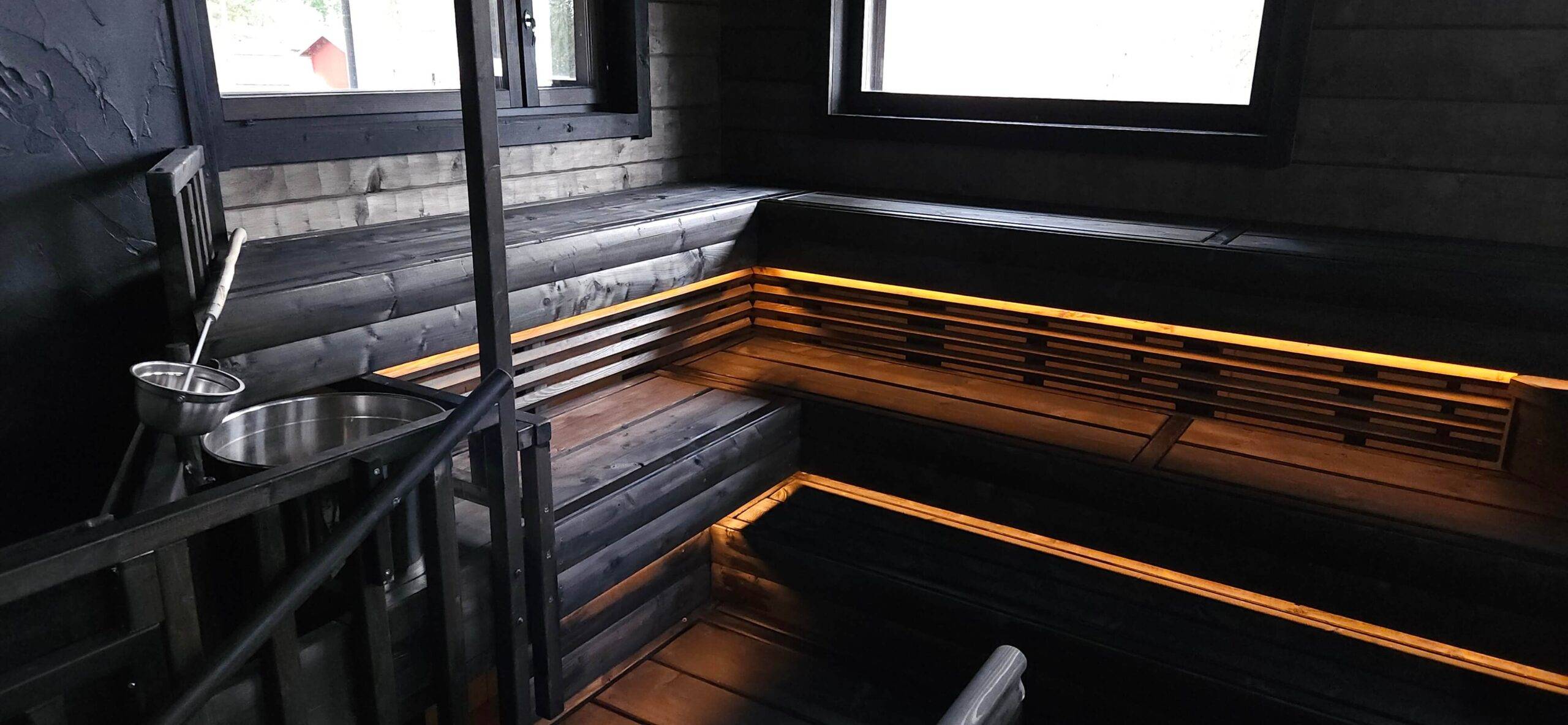 alla base dei soffitti della sauna in legno scuro, sono state installate delle strisce LED di colore giallo caldo per illuminare verso il basso