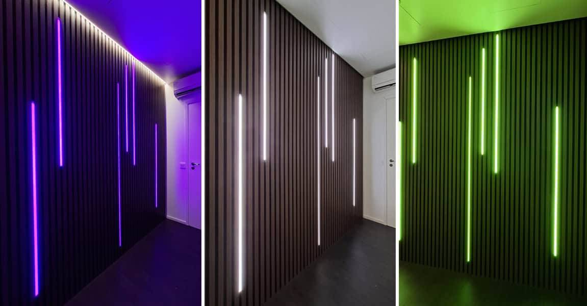 Una parete scura elegantemente pannellata con i LED di LedStore.fi che brillano in blu, bianco e verde.