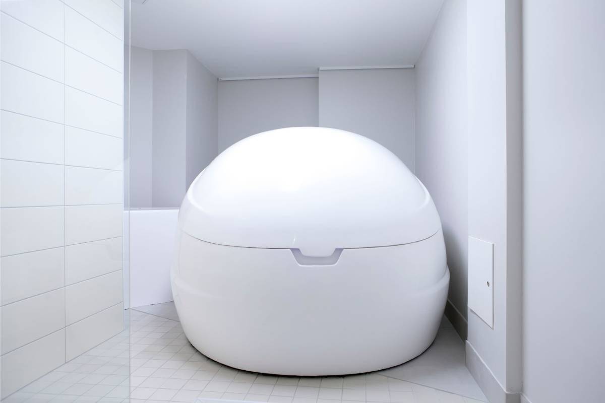 Il negozio online LedSto.fi presenta una grande vasca ovale bianca per la stimolazione sensoriale, situata in uno spazio minimalista con pareti e pavimento piastrellati. Le luci LED soffuse evidenziano la superficie liscia e il coperchio chiuso della vasca, sottolineando il suo design per l'isolamento o la terapia di galleggiamento.