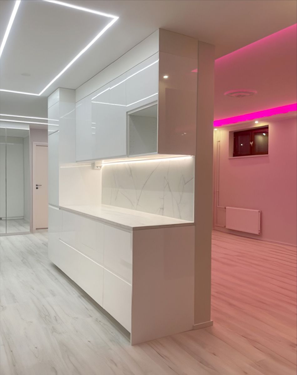 Linea luminosa quadrata sul soffitto della cucina e luce a led rosa in soggiorno.